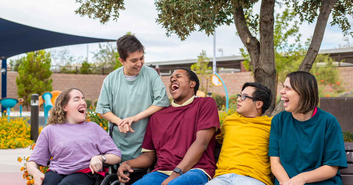 Group of happy NDIS participants laughing together outdoors